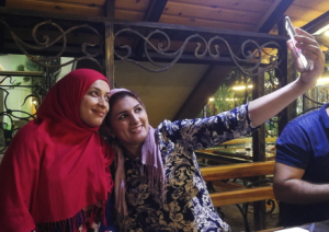 kuvassa kaksi huivipäistä naista ottaa selfietä